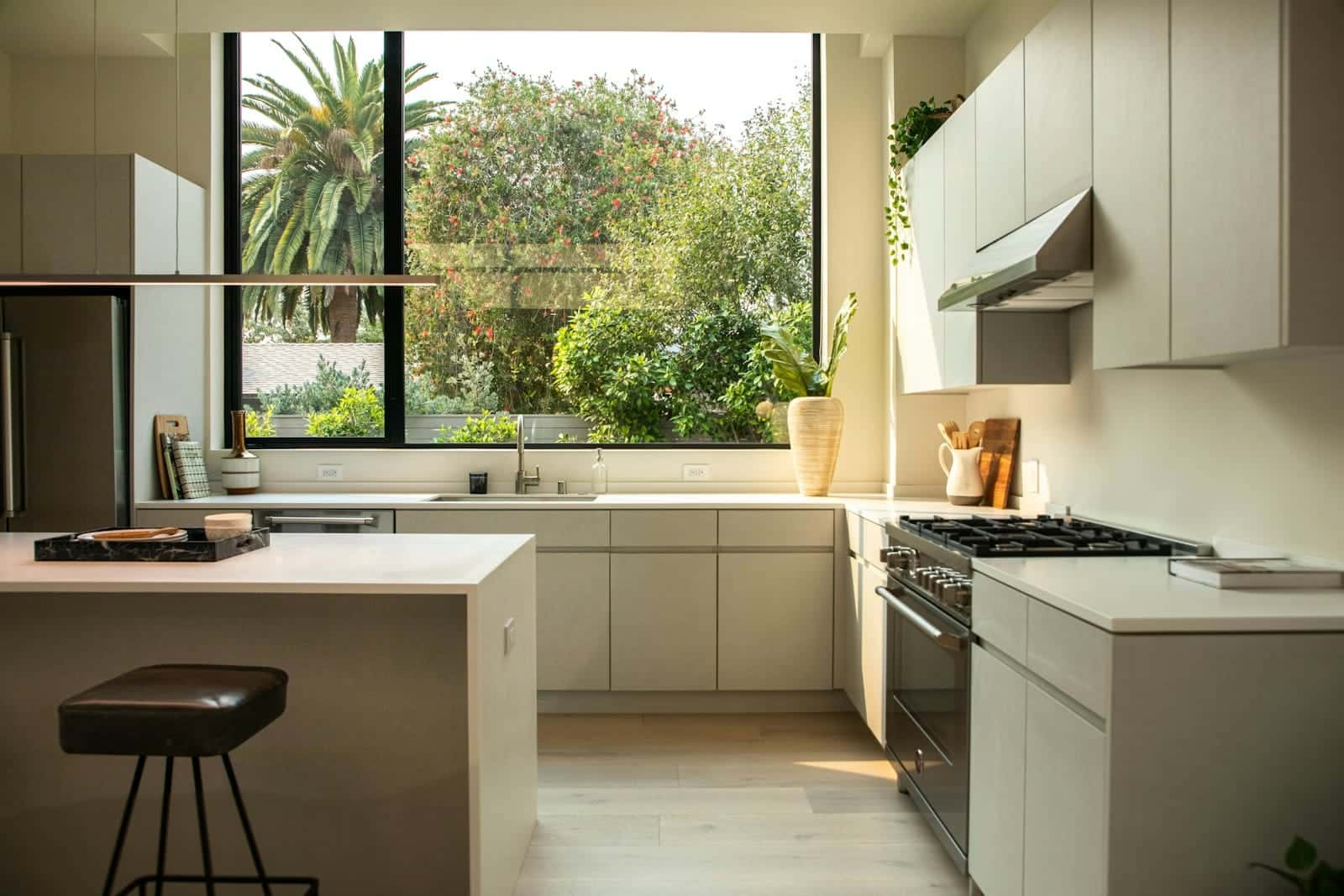Cocina clara con un ventanal que da a un jardín, iluminada por el sol