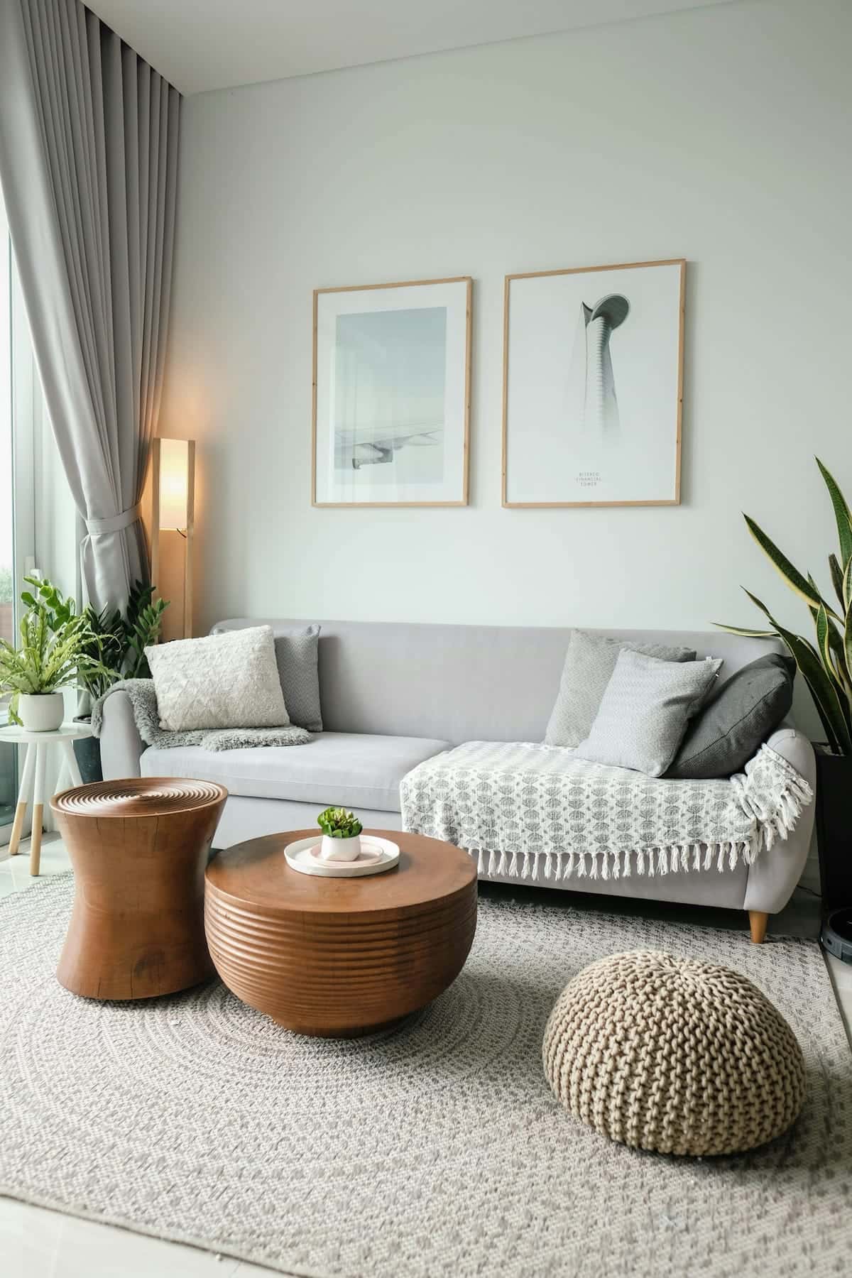 Living luminoso con un gran ventanal, un sofá gris y una mesa de centro de madera